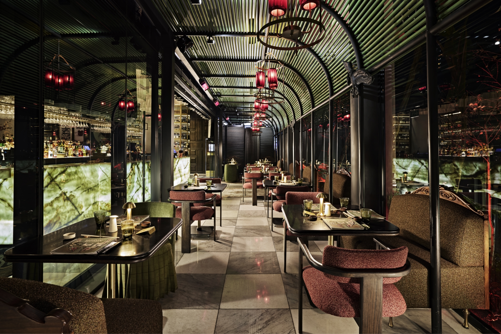 Sophisticated event venue interior with curved bamboo ceiling, red lanterns, marble floors, and intimate seating arrangements creating an exclusive atmosphere perfect for private event venue hire